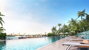 large still pool surrounded by cabana chairs and palm trees outside Moda Terrace Miami Residences